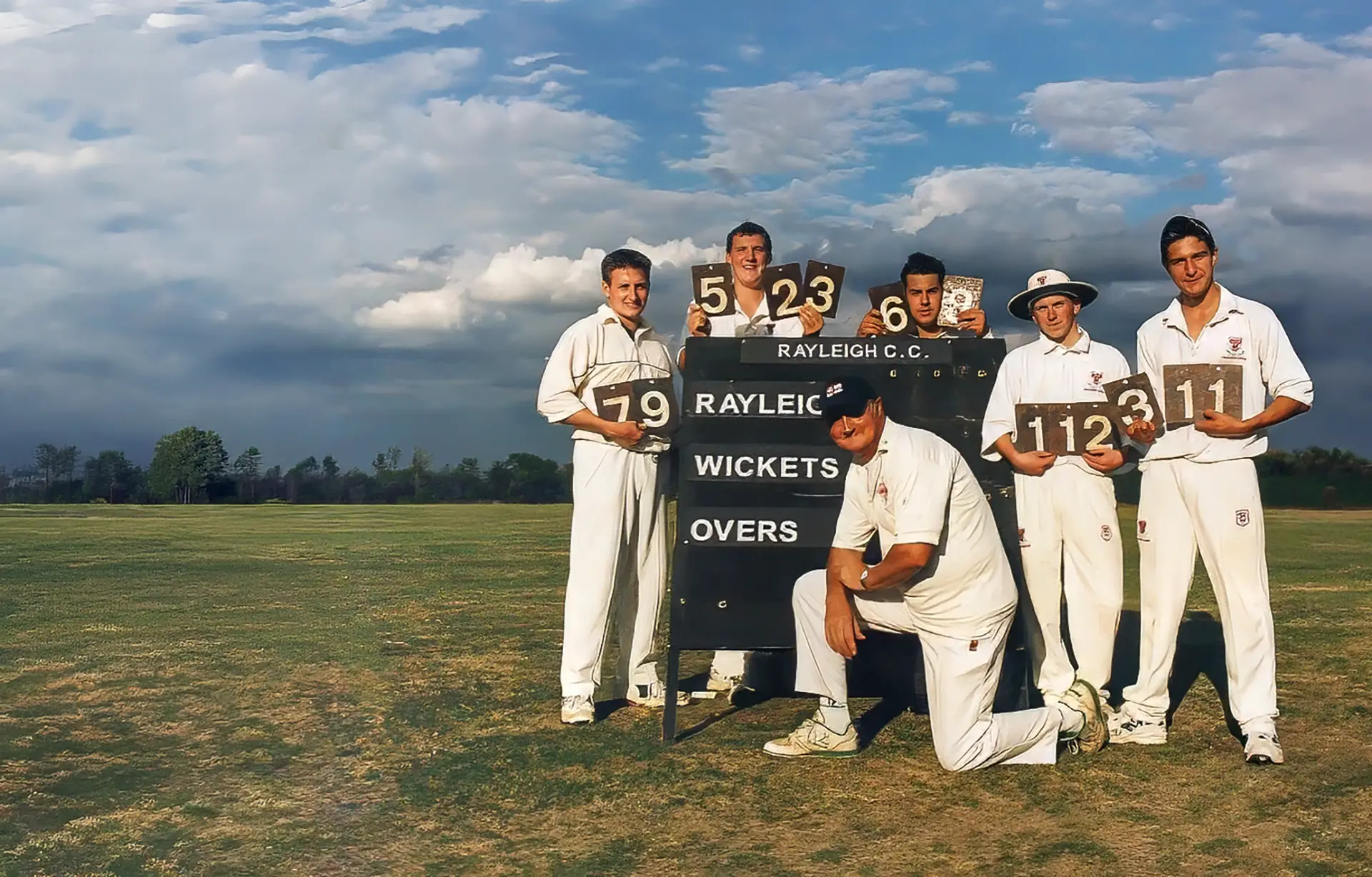 Rayleigh CC players with the club scoreboard